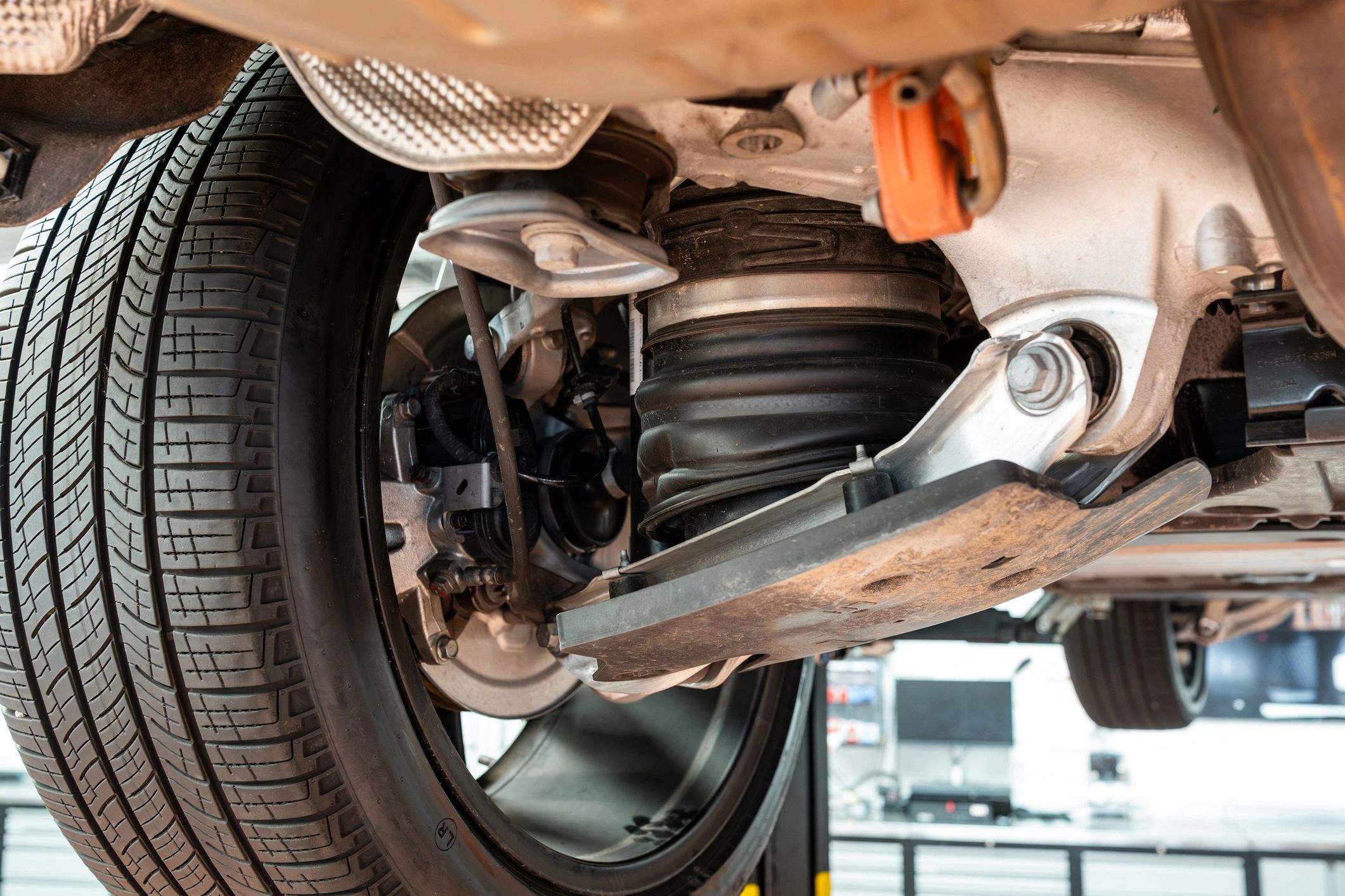 Axle and suspension components on a lifted vehicle in a workshop